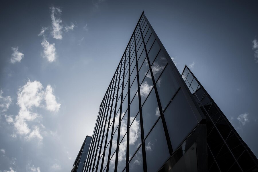 abstract-architecture-background-with-blue-sky-modern-office-building-with-reflection-window-glass_548832-4116